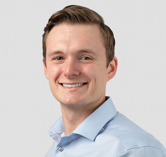 Man smiles at camera for professional headshot.