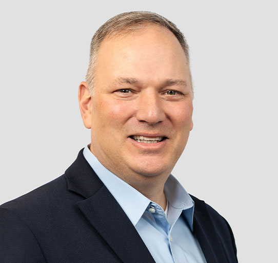 Man smiles at camera for professional headshot